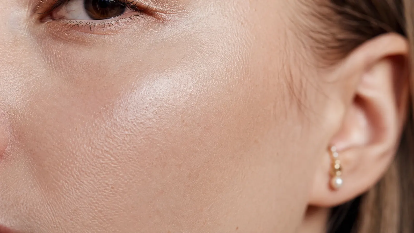 Close-up of healthy dewy skin texture on cheek, no redness or flaking